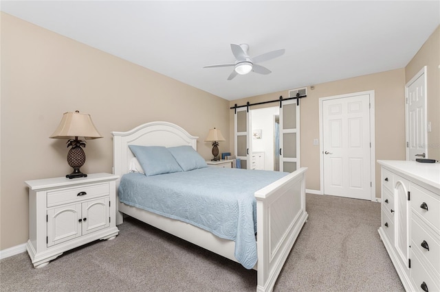 1551 Beach Rd Unit 412, Englewood, FL 34223 - bedroom featuring a barn door, light carpet, baseboards, and a ceiling fan