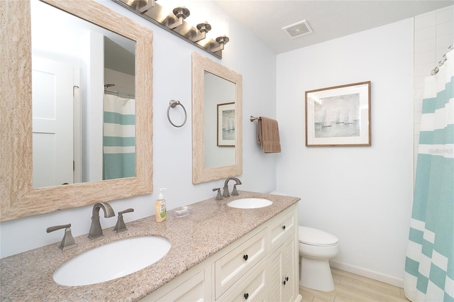 301 S Gulf Blvd Unit 419, Placida, FL 33946 - bathroom with toilet, a sink, double vanity, and visible vents
