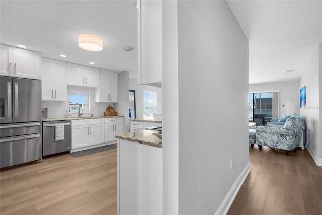 316 Coldeway Dr Unit 29, Punta Gorda, FL 33950 - kitchen featuring white cabinets, a sink, stainless steel appliances, and light wood finished floors