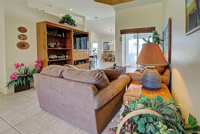 1078 Boundary Blvd, Rotonda West, FL 33947 - living room featuring a textured wall, light tile patterned flooring, a chandelier, lofted ceiling, and baseboards