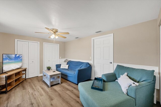 living area with visible vents, a ceiling fan, and light wood-style floors