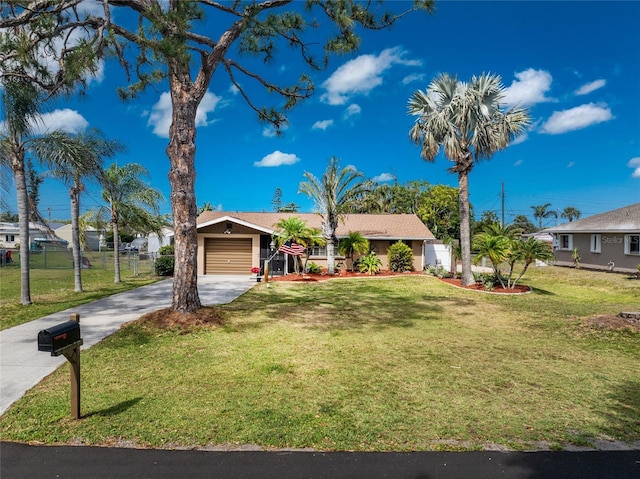 1670 Faust Dr, Englewood, FL 34224 - single story home featuring a front lawn, fence, a garage, and concrete driveway
