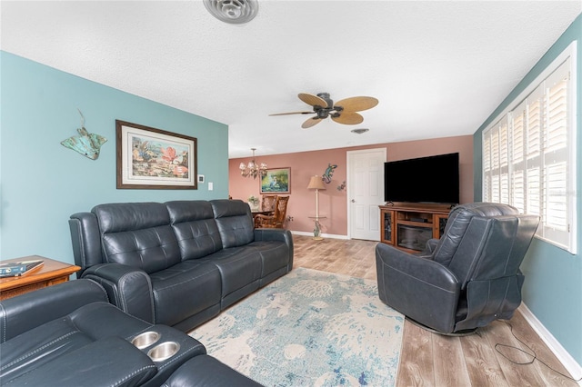 1670 Faust Dr, Englewood, FL 34224 - living area with visible vents, light wood-style flooring, baseboards, and ceiling fan with notable chandelier