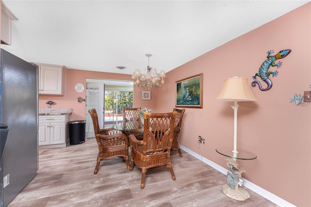 1670 Faust Dr, Englewood, FL 34224 - dining room with visible vents, light wood-style flooring, an inviting chandelier, and baseboards