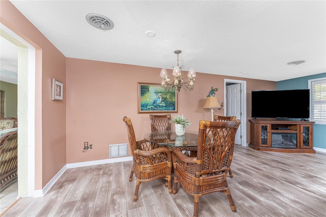 1670 Faust Dr, Englewood, FL 34224 - dining room featuring a notable chandelier, visible vents, and wood finished floors