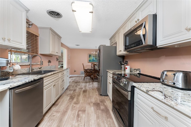 1670 Faust Dr, Englewood, FL 34224 - kitchen with visible vents, a sink, stainless steel appliances, light wood finished floors, and a toaster