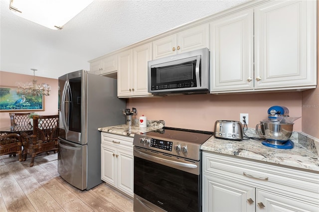 1670 Faust Dr, Englewood, FL 34224 - kitchen featuring a toaster, light wood-style floors, light stone counters, and appliances with stainless steel finishes
