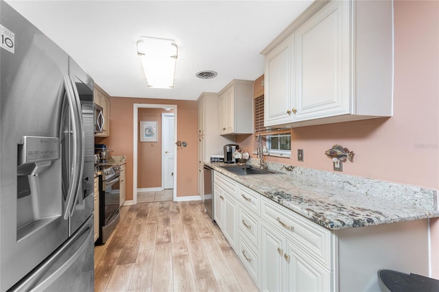 1670 Faust Dr, Englewood, FL 34224 - kitchen featuring light wood-type flooring, light stone countertops, visible vents, stainless steel appliances, and a sink