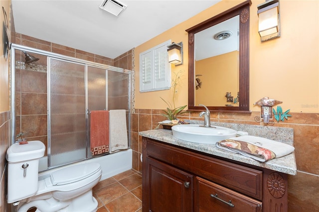 1670 Faust Dr, Englewood, FL 34224 - full bath with visible vents, tile walls, tile patterned flooring, and enclosed tub / shower combo