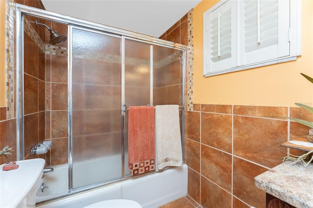 1670 Faust Dr, Englewood, FL 34224 - full bathroom featuring tile walls, toilet, and shower / bath combination with glass door