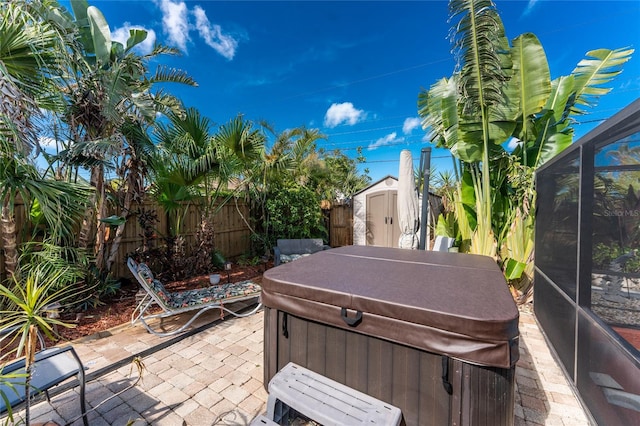 1670 Faust Dr, Englewood, FL 34224 - view of patio with a storage shed, a fenced backyard, a lanai, an outbuilding, and a hot tub