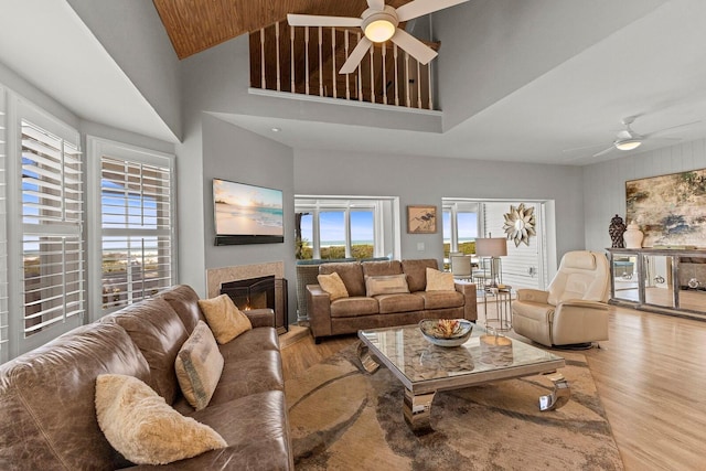 17 Seawatch Dr, Boca Grande, FL 33921 - living area featuring a ceiling fan, wood finished floors, a warm lit fireplace, and high vaulted ceiling