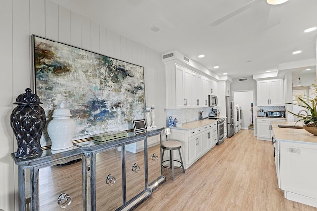 17 Seawatch Dr, Boca Grande, FL 33921 - kitchen with white cabinets, stainless steel appliances, light countertops, and tasteful backsplash