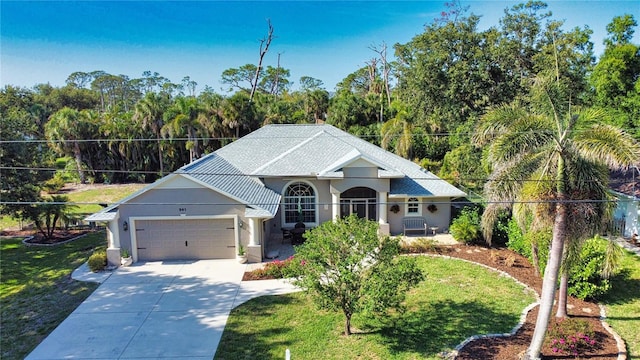 941 Elwood Ave, Englewood, FL 34223 - view of front of property with stucco siding, a garage, concrete driveway, and a front lawn