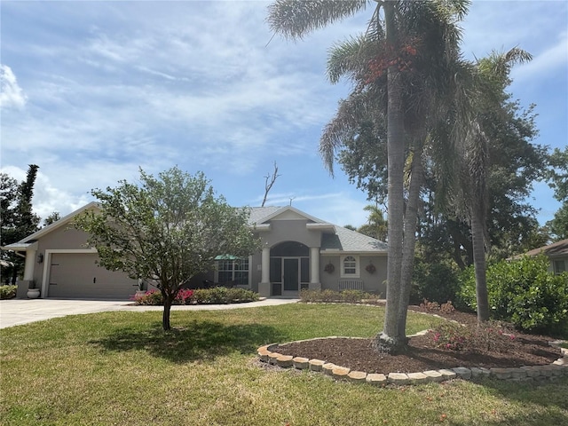941 Elwood Ave, Englewood, FL 34223 - ranch-style house with driveway, an attached garage, a front yard, and stucco siding