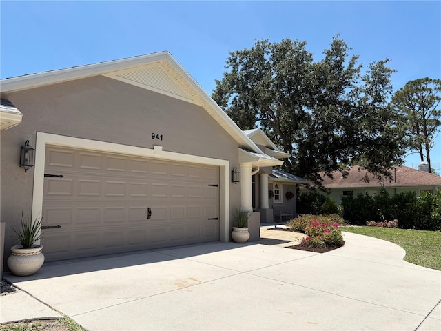941 Elwood Ave, Englewood, FL 34223 - view of front facade featuring stucco siding, driveway, and an attached garage