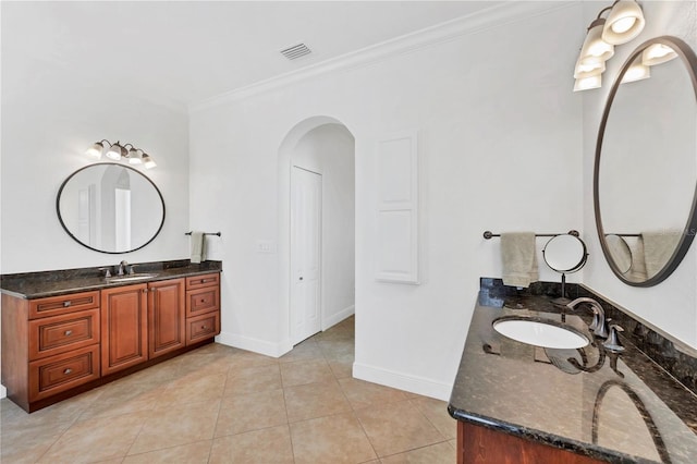 full bathroom featuring two vanities, a sink, baseboards, visible vents, and crown molding