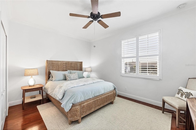 bedroom with ornamental molding, baseboards, ceiling fan, and wood finished floors
