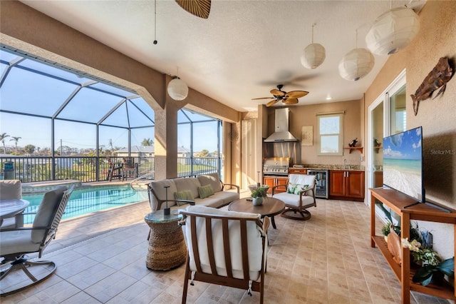 view of patio / terrace with wine cooler, outdoor lounge area, an outdoor pool, an outdoor kitchen, and ceiling fan
