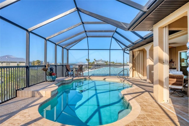 view of pool with a patio area, a fenced in pool, and glass enclosure