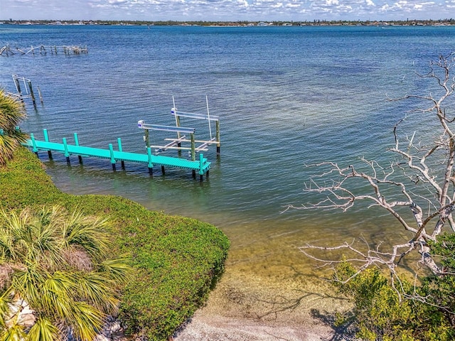 dock area featuring boat lift and a water view
