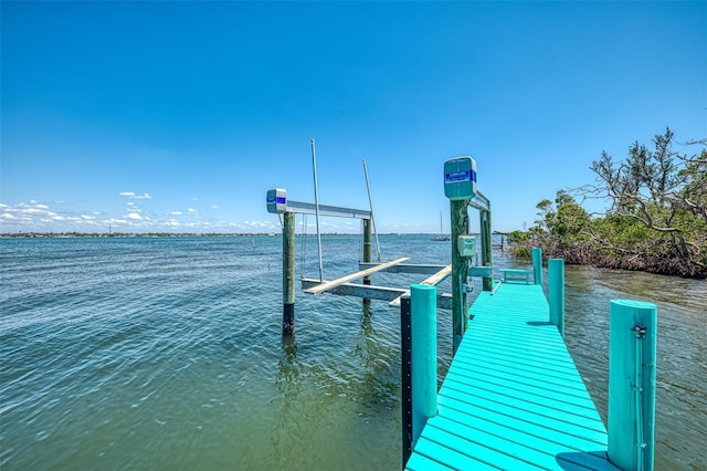 dock area featuring boat lift and a water view