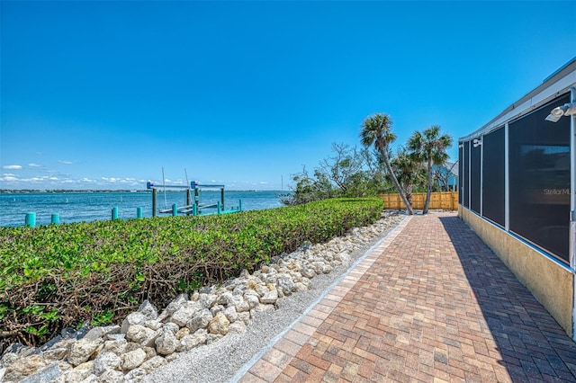 exterior space featuring fence and a water view