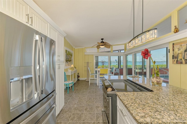 kitchen featuring white cabinets, stainless steel appliances, a ceiling fan, and a healthy amount of sunlight