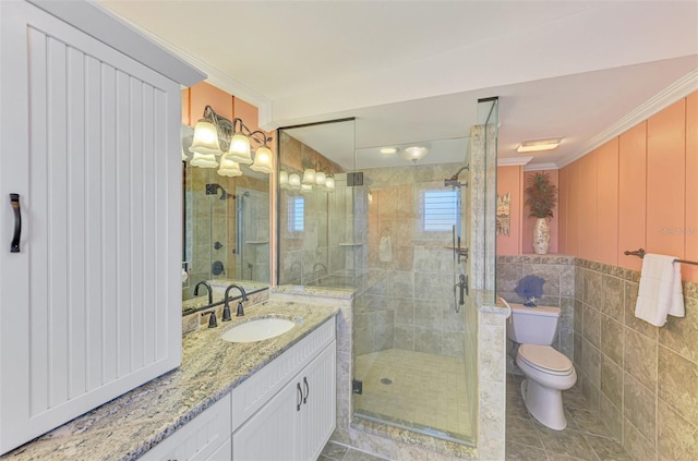 bathroom featuring crown molding, a stall shower, vanity, tile walls, and toilet