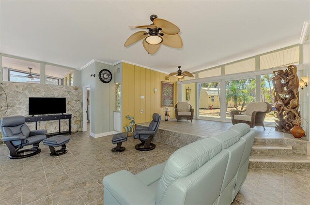 tiled living room featuring ornamental molding, vaulted ceiling, and a ceiling fan
