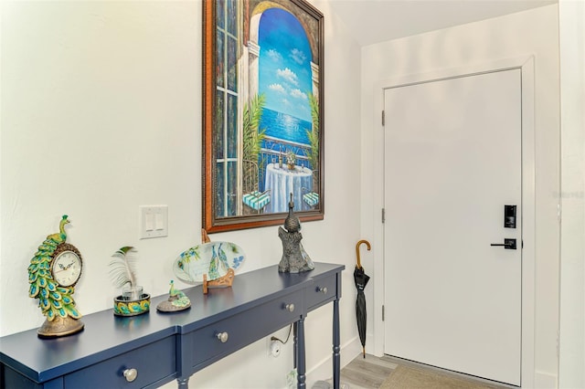 foyer entrance with light wood finished floors and baseboards