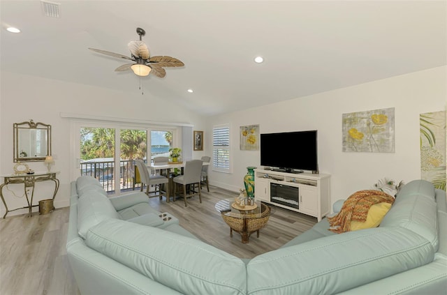 living area featuring light wood-style floors, visible vents, baseboards, and a healthy amount of sunlight