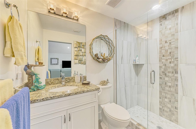 bathroom featuring toilet, vanity, visible vents, and a stall shower