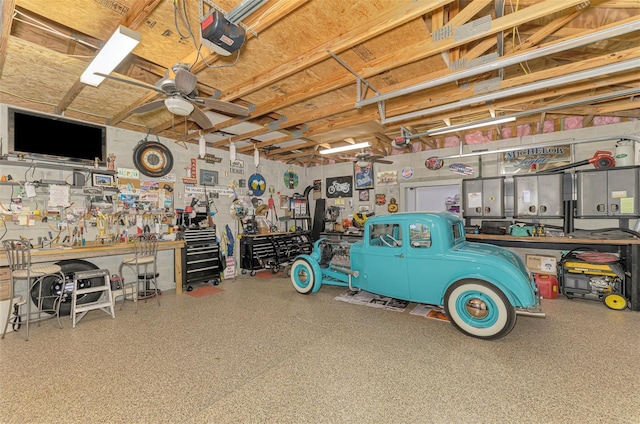 garage with a workshop area, a ceiling fan, and a garage door opener