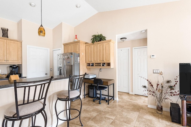 7089 Benson St, Englewood, FL 34224 - kitchen featuring light brown cabinets, dark countertops, a breakfast bar, and stainless steel fridge