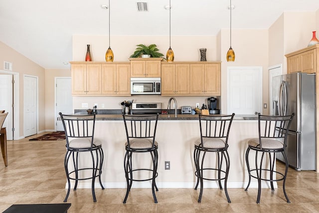 7089 Benson St, Englewood, FL 34224 - kitchen featuring stainless steel appliances, light brown cabinets, visible vents, and a breakfast bar