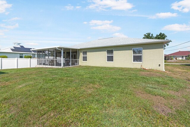 7089 Benson St, Englewood, FL 34224 - rear view of property with fence, a lawn, a sunroom, and stucco siding