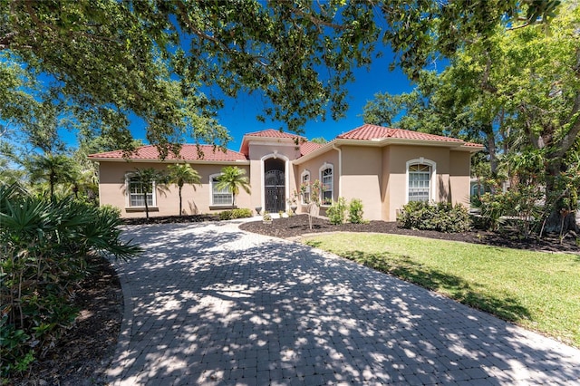 26 Saint Croix Way, Englewood, FL 34223 - mediterranean / spanish-style house featuring a tile roof, a front yard, and stucco siding