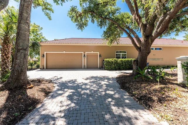 26 Saint Croix Way, Englewood, FL 34223 - view of front of house featuring a garage, a tile roof, stucco siding, and decorative driveway