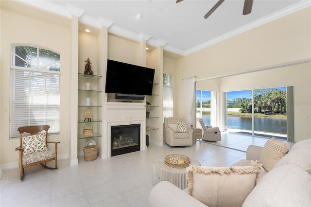 26 Saint Croix Way, Englewood, FL 34223 - living room featuring a glass covered fireplace, a ceiling fan, light tile patterned flooring, and crown molding