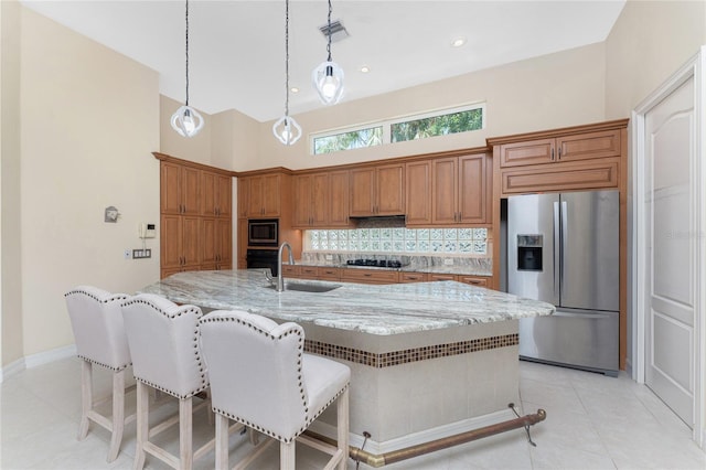 26 Saint Croix Way, Englewood, FL 34223 - kitchen featuring light stone counters, a sink, black appliances, brown cabinets, and light tile patterned flooring