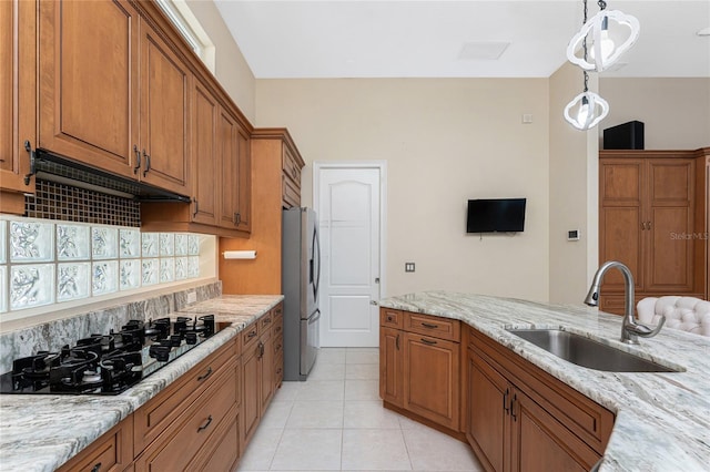 26 Saint Croix Way, Englewood, FL 34223 - kitchen with brown cabinetry, stainless steel refrigerator with ice dispenser, black gas stovetop, and a sink