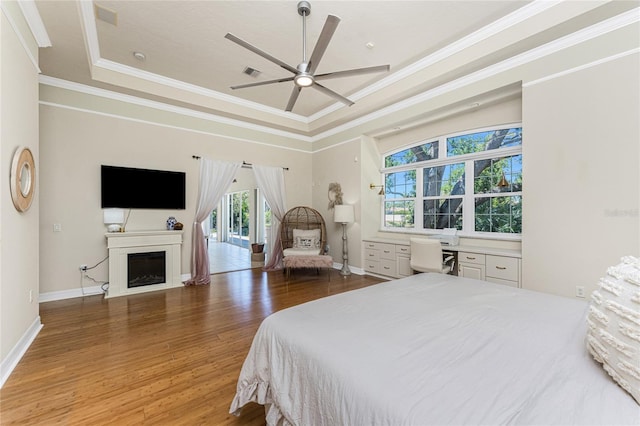 26 Saint Croix Way, Englewood, FL 34223 - bedroom with crown molding, wood finished floors, a fireplace, baseboards, and a raised ceiling