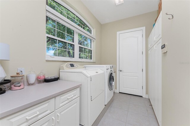 26 Saint Croix Way, Englewood, FL 34223 - laundry area featuring washer and dryer, baseboards, cabinet space, and light tile patterned floors