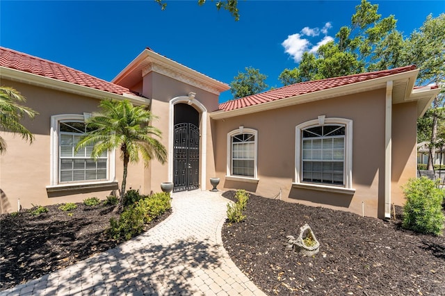 26 Saint Croix Way, Englewood, FL 34223 - property entrance with a tiled roof and stucco siding