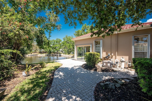 26 Saint Croix Way, Englewood, FL 34223 - exterior space featuring stucco siding, a tile roof, a water view, and a patio