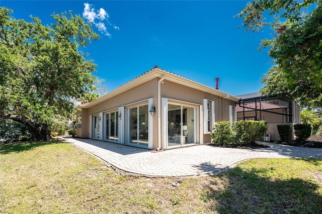 26 Saint Croix Way, Englewood, FL 34223 - rear view of property with a lawn, a lanai, a patio, and stucco siding