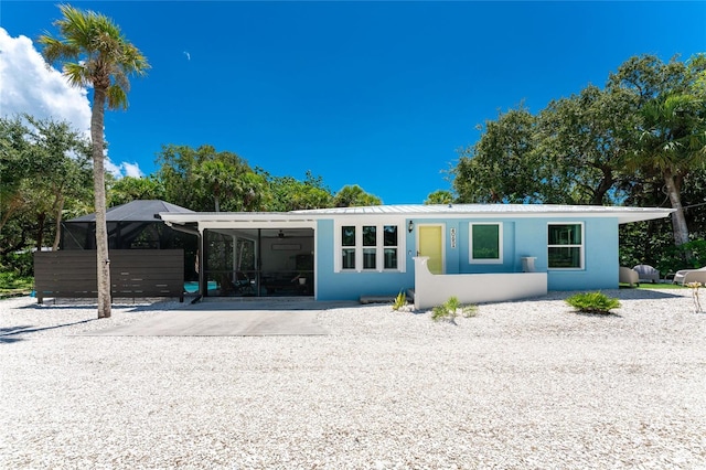 view of front of house with a carport, driveway, and stucco siding