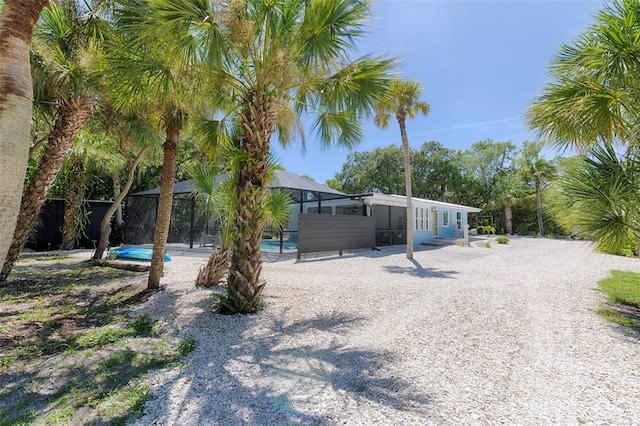 view of yard with an outdoor pool, a patio area, and glass enclosure