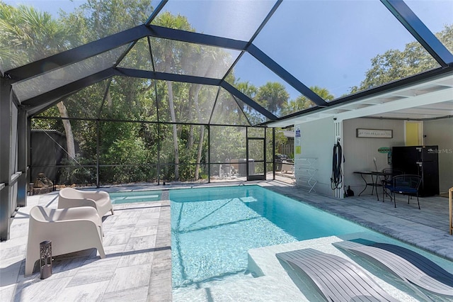 outdoor pool with a patio and glass enclosure
